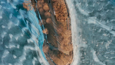 Aerial-shot-of-peninsula-surrounded-by-frozen-lake