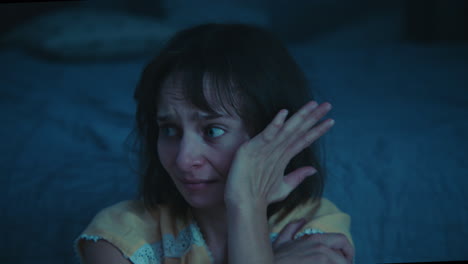 a traumatised and disoriented girl sits on the bedroom floor