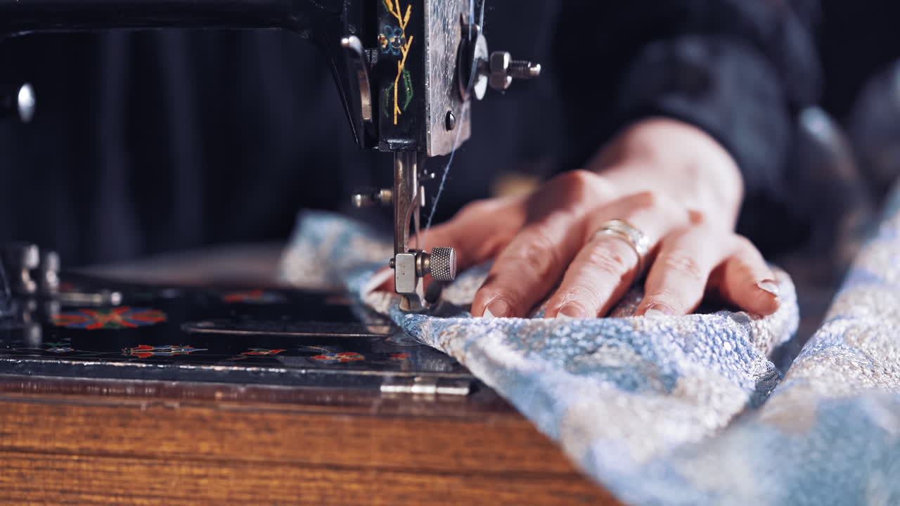 Woman hands behind sewing. Seamstress woman sewing clothes with sewing machine