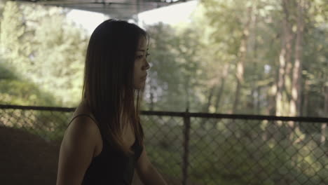 closeup of asian woman in black walking under lions gate bridge, slowmo