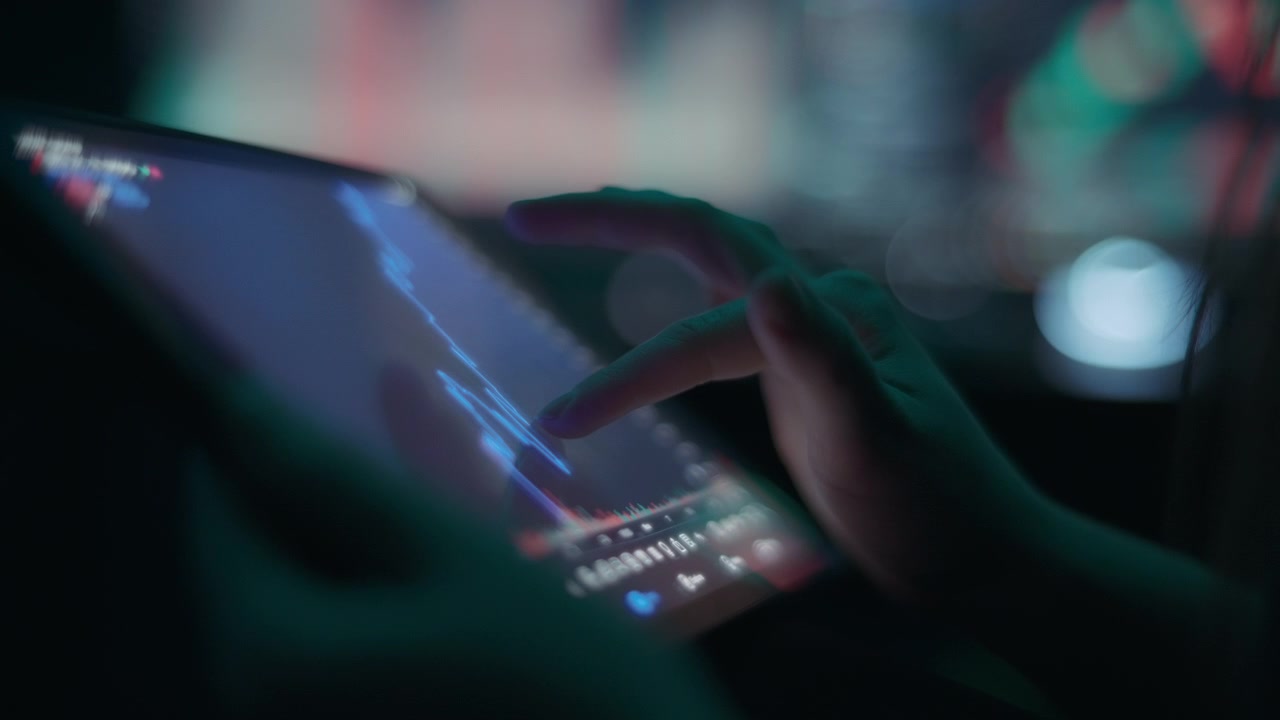 Trader picking stocks by analyzing the market graph on a tablet
