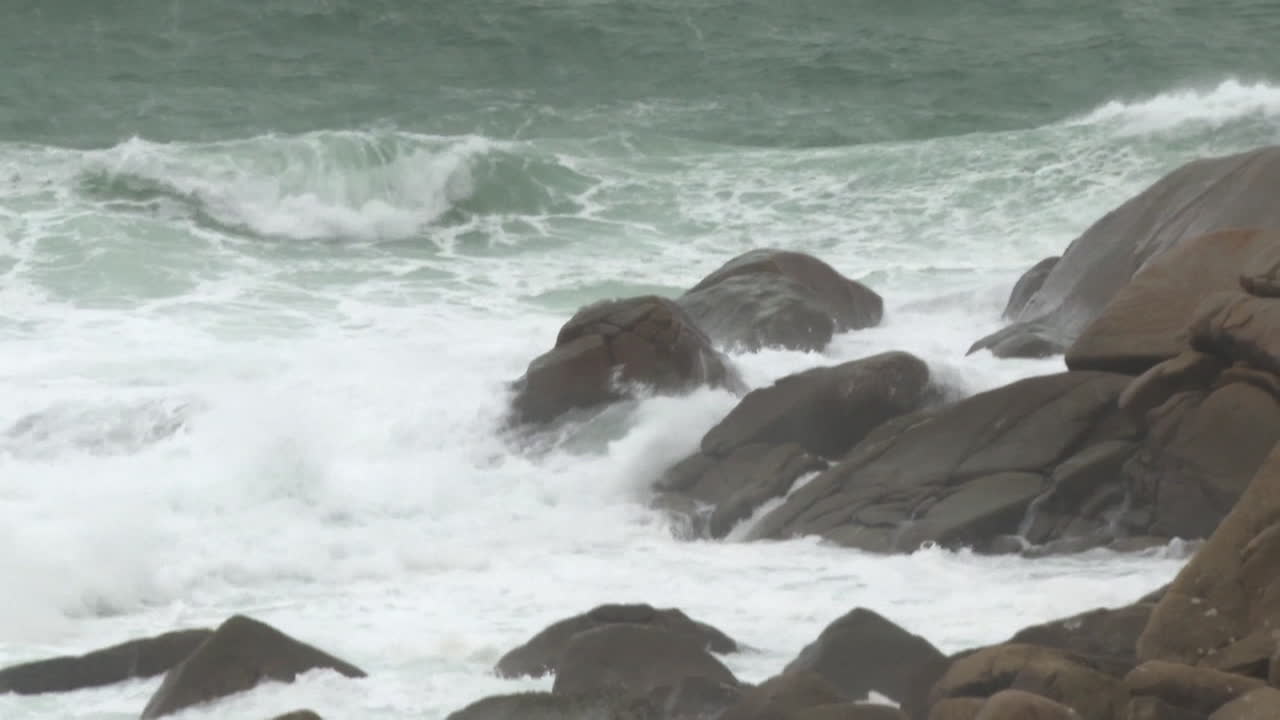 Powerful waves crashing against rocks on a stormy coast