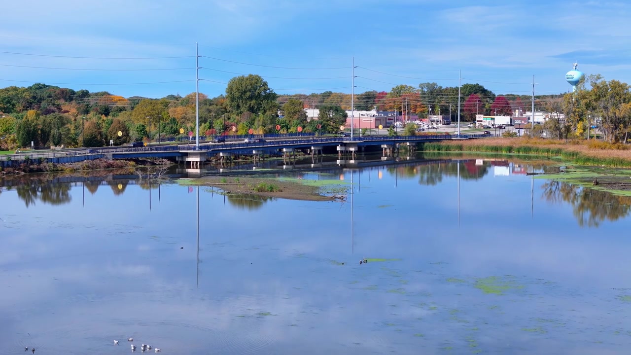 Macatawa-elven med North River Ave-broen og høstløvverk i Holland, Michigan