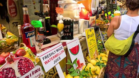 mujer comprando frutas frescas y jugos