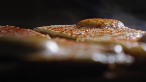 primer plano de huevos calientes soleados hacia arriba espolvoreados con polvo de cayena en la parte superior