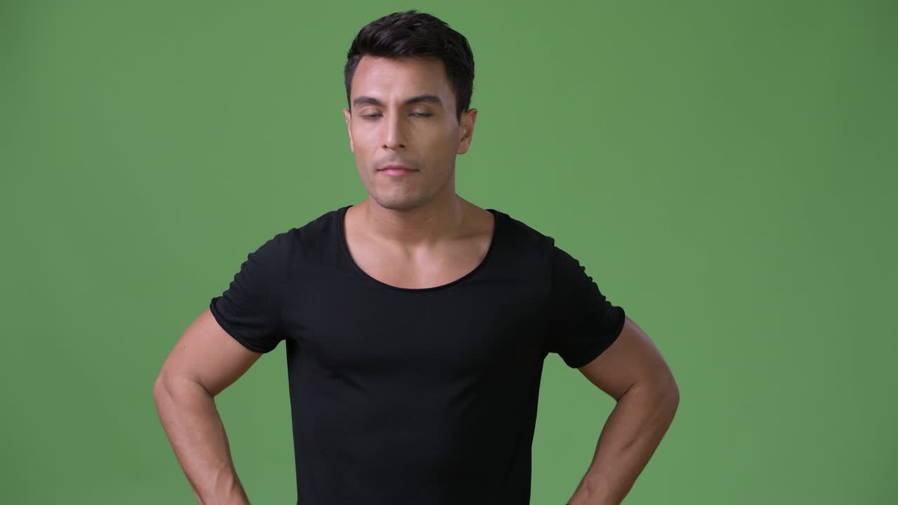 초록색 배경에 젊은 잘생긴 히스패닉 남자