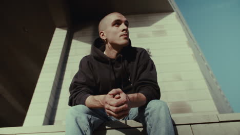 young man sitting outside building