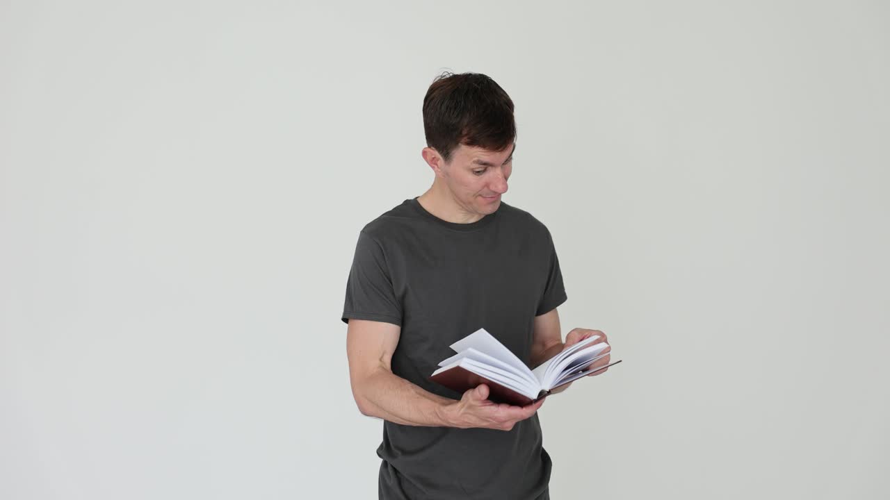 Man reading a book with surprised and curious expressions