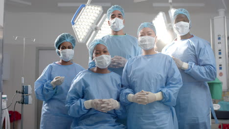 Portrait-of-diverse-surgeons-wearing-surgical-gowns-in-operating-theatre,-slow-motion