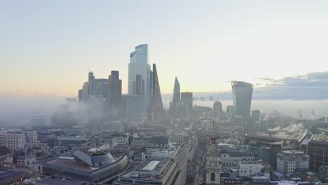 Stabile-Luftaufnahme-Des-Nebligen-Sonnenaufgangs-Im-Zentralen-Geschäftsviertel-Von-London