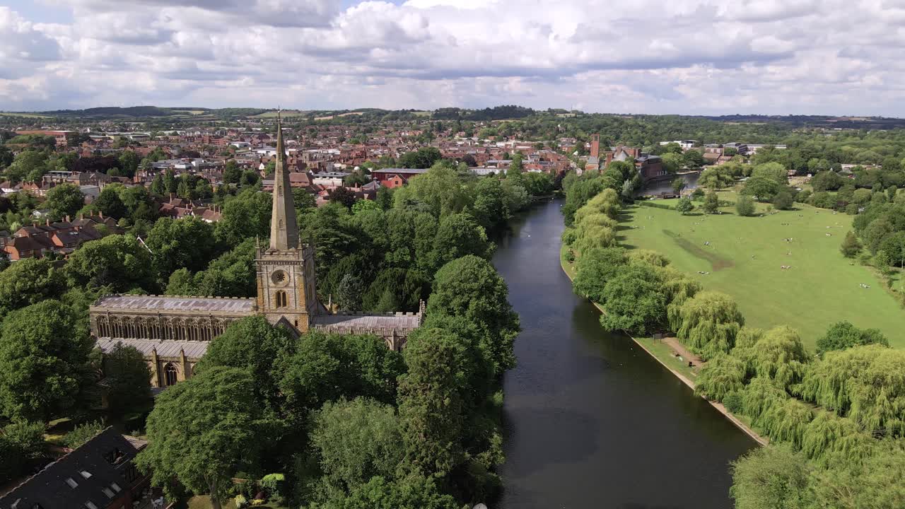 Carrellata aerea della Chiesa della Santissima Trinità e del fiume Avon nel tranquillo paesaggio suburbano del Warwickshire