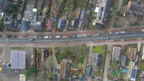 Top-Down-Antenne-Von-Autos,-Die-über-Eine-Ruhige-Straße-Durch-Eine-Wunderschöne-Kleinstadt-Fahren