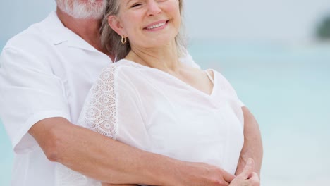 loving male female senior caucasian couple on beach