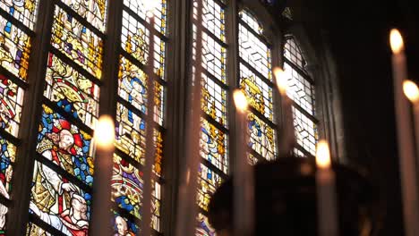 Stained-glass-windows-with-candlelight-in-a-historic-church