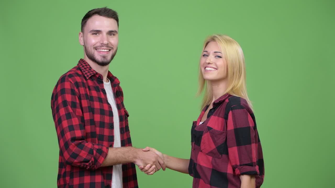 Young happy couple shaking hands together