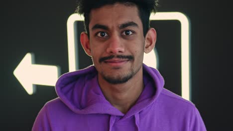 close up portrait of south asian young man winking at camera, wear hoodie