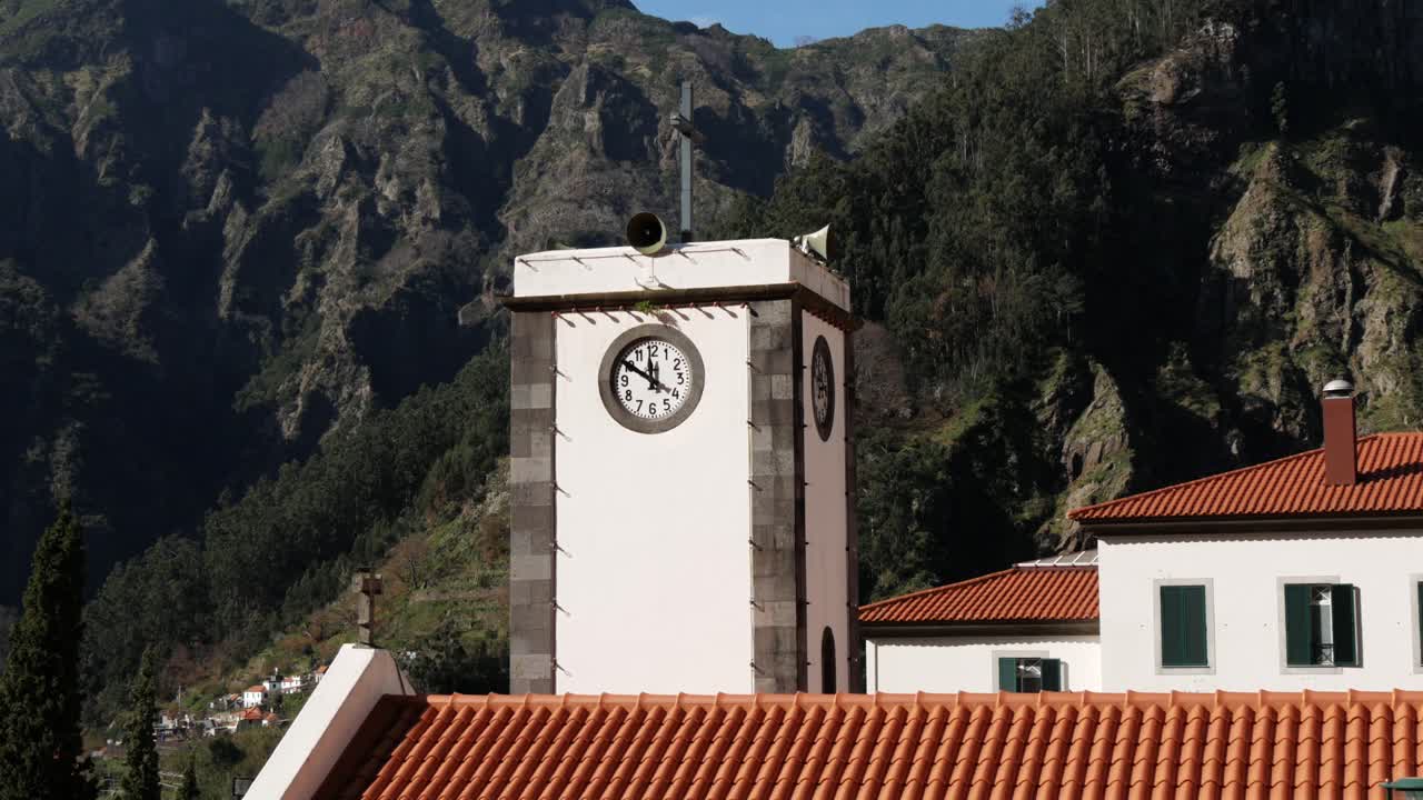 Torre dell'orologio circondata da montagne nell'isola di Madeira, Portogallo