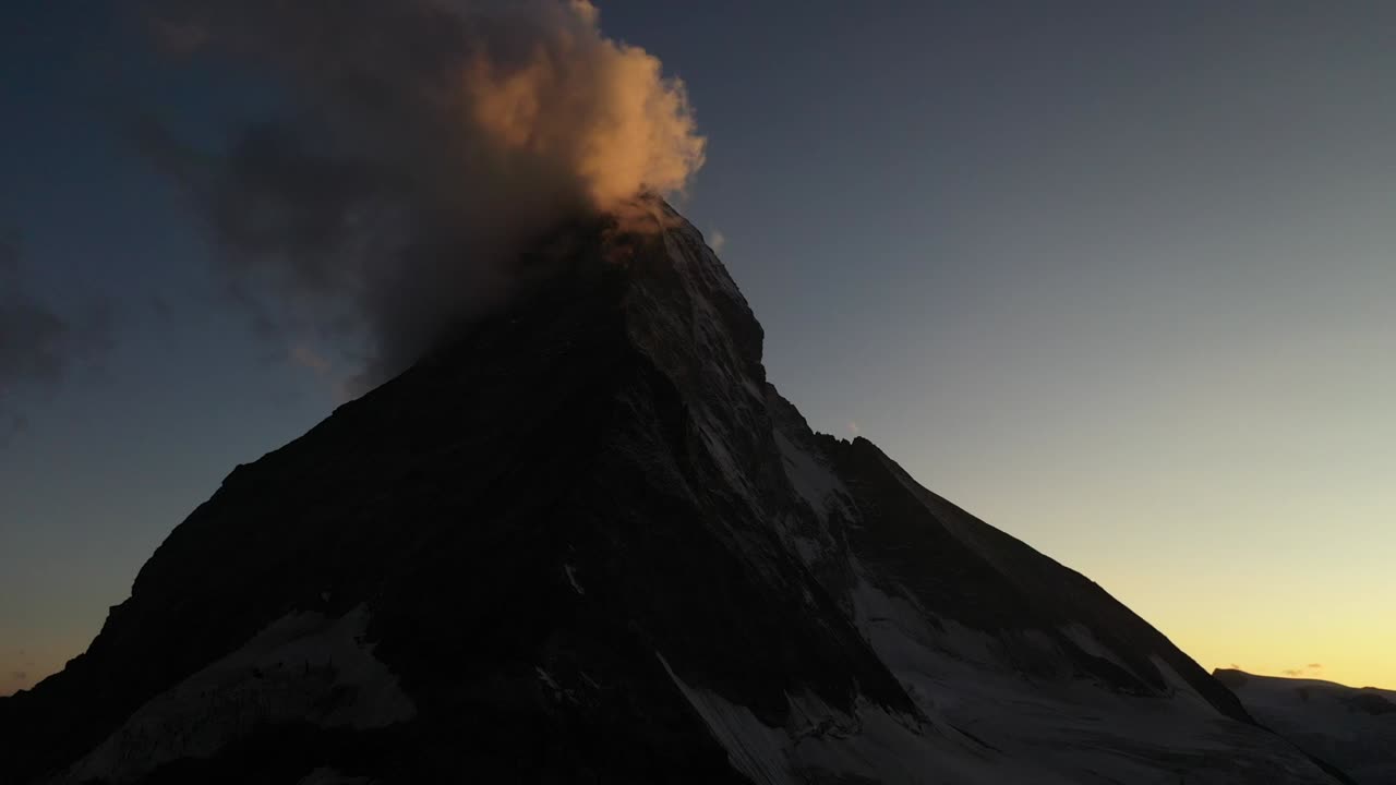 tiro aéreo lento moviéndose hacia atrás, frente a matterhorn, suiza durante un amanecer colorido y armonioso
