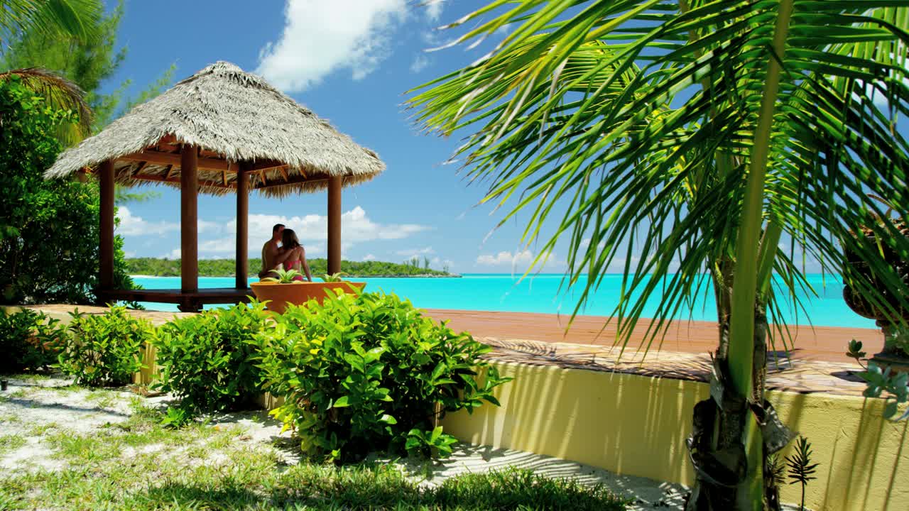 кавказская пара сидит в хижине на пляже.