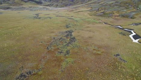 Vista-De-Pájaro-Del-Valle-Abierto-Del-Paisaje-Islandés-Cubierto-De-Musgo-Con-Un-Hermoso-Río-Que-Lo-Atraviesa