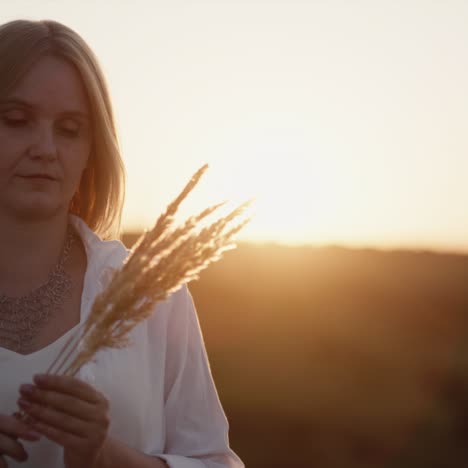 Woman-stands-at-sunset-in-a-field-of-grass-1