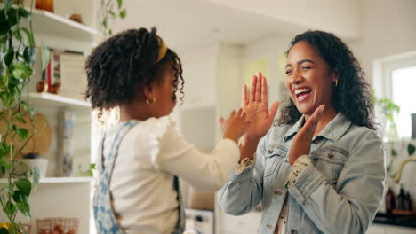 happy mother and daughter playing together in the kitchen
