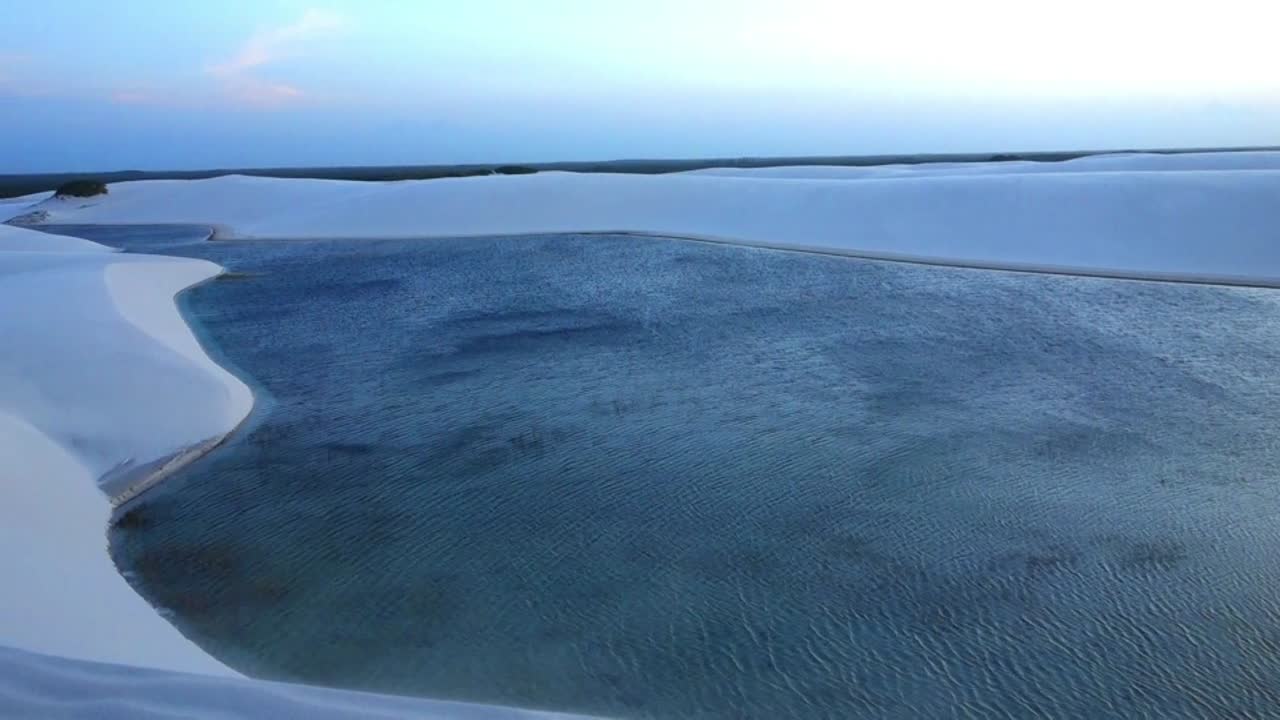 Evening on beautiful lagoon and sand dune view.Dunes and Lagoons in Lencois Maranhenses National Park, Maranhao state.Wave dunes and rainwater lagoons sunset landscape