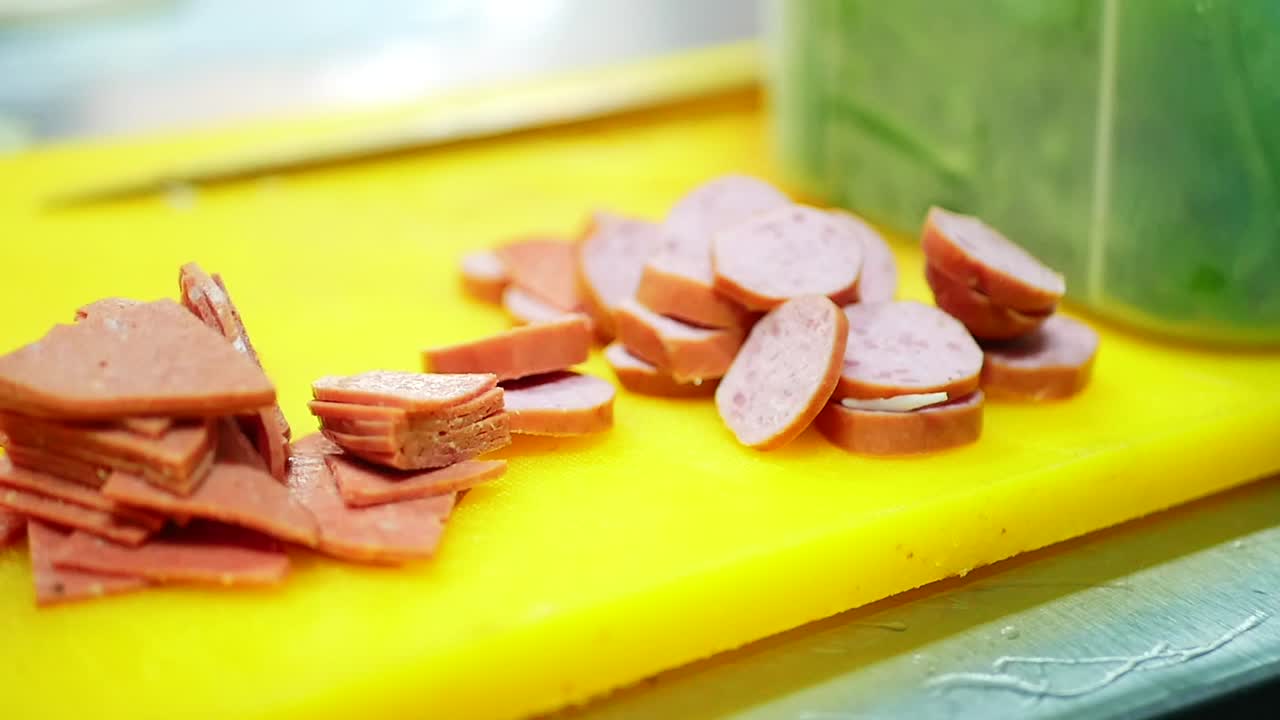 노란색 커팅 보드에 조각으로 자른 소시지, 슬라이더 샷