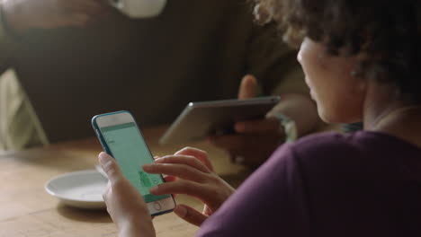 joven mujer de negocios usando un teléfono inteligente en un café navegando por documentos corporativos leyendo correo electrónico trabajando en un teléfono móvil de cerca