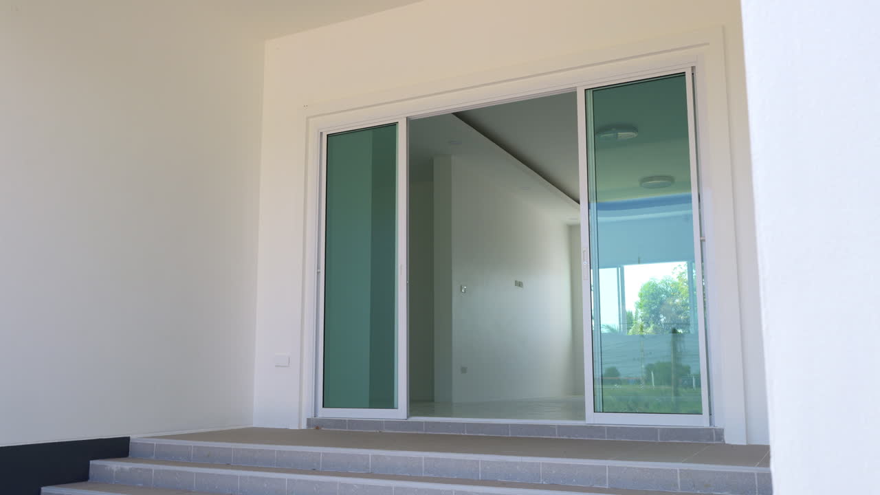 오른쪽에서 왼쪽으로 어보면 입구의 전면과 집의 거실로 이어지는 유리 문이 보인다.