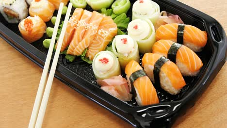 rollos de sushi con salmón en una bandeja de plástico