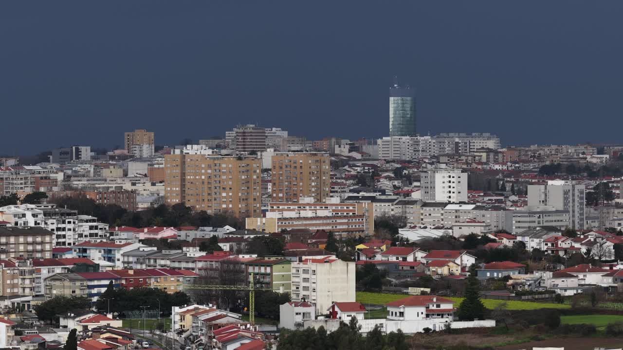 Città piena di edifici con nuvole di pioggia sullo sfondo