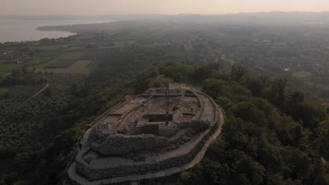 Panorama-Aéreo-De-La-Cumbre-De-Rocca-Di-Manerba,-área-Del-Lago-Garda-Bajo-La-Suave-Luz-Del-Sol