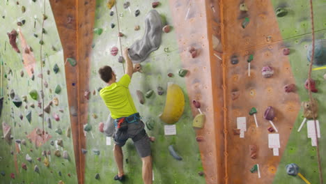 concepto de actividad deportiva de escalada: hombre escalador en la pared. concepto de actividad esportiva de escalado en interiores: hombre escalado en la parede de escalada artificial.