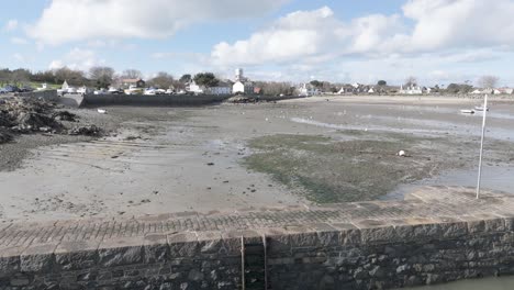 바르도 항구 (bordeaux harbour) 과 게르니 항구 (guernsey harbour) 의 저류, 항구 벽, 모래 위에 건조하는 배, 밝은 날 배경에 해변과 오두막이 나타납니다.