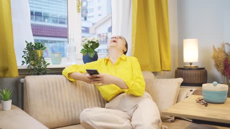 Young-woman-smiling-at-phone-message.