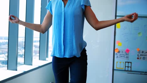 Female-executive-performing-yoga-at-her-desk