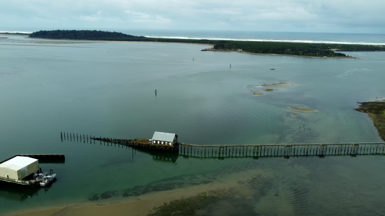 US, Oregon, Garabaldi, , 2025-03-18 - Drone view of the historic Coast Guard lifeboat launch station on Nehalem Bay with the Pacific Ocean beyond.