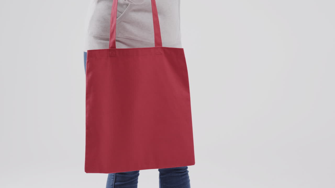 ⁇ 색 후드 위에 빨간 가방을 들고 있는  ⁇ 색 후드 위를 입은 백인 여성, 복사 공간, 슬로우 모션