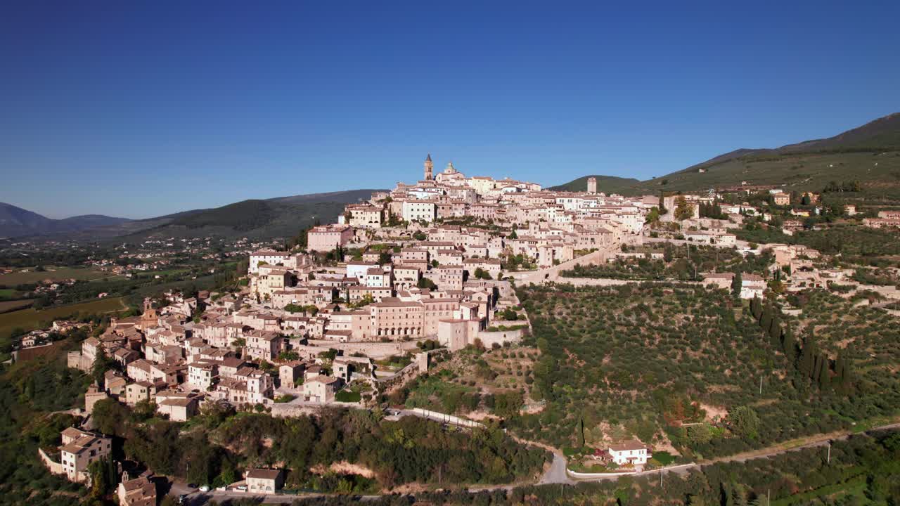 Paesaggio aereo della città medievale di Trevi in cima a una collina verde, Italia.
