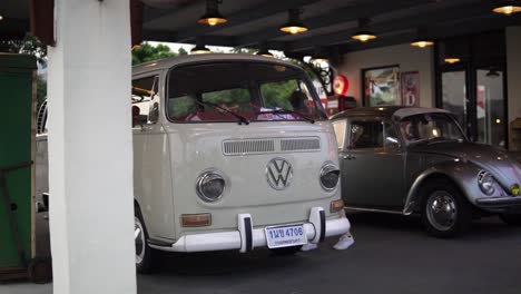 female model checking out classic volkswagon vintage cars on public display at the rot fai night market in bangkok, thailand