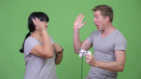young multi-ethnic couple playing games and winning together