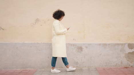 young woman using smartphone walking at street