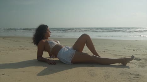 sexy indian model lying on the sands of a beach on a hot sunny day in indian ocean - sexy indian girl on a beach