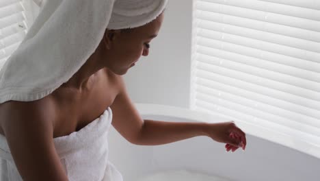 african american woman touching water in the bath tub in the bathroom at home