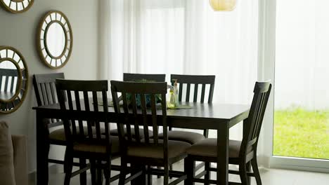 dining room with table, chairs and mirrors next to a window