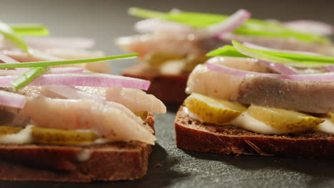 open-faced sandwiches with smoked fish, onions, and pickles