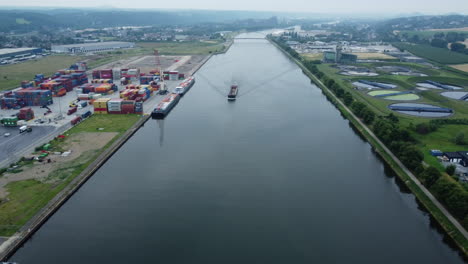 canal with cargo ship and industrial complex