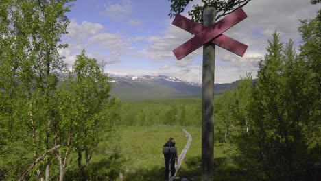 un excursionista se aleja de la cámara por un sendero sobre las montañas