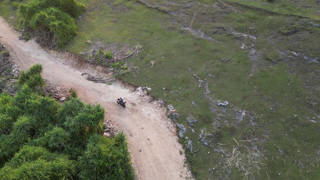 pistas aéreas motociclista montando en un camino de tierra áspera encima de los acantilados costeros